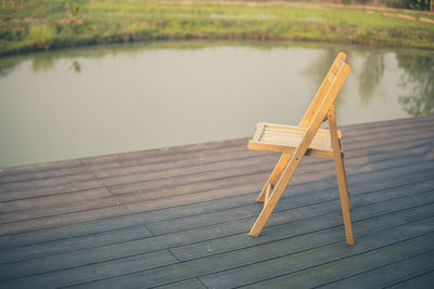 High angle view of wooden table on pier at lake