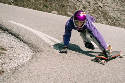 Low section of man skateboarding on road