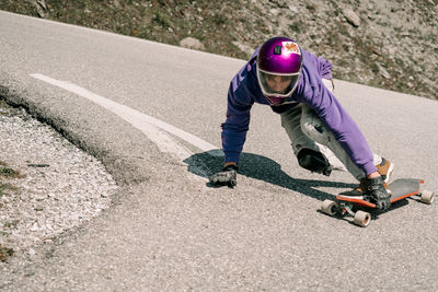 Downhill skateboarder on alpine road