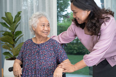 Side view of smiling couple standing at home