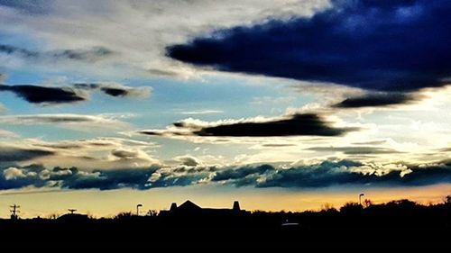 Silhouette of landscape against cloudy sky