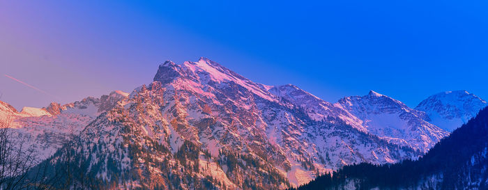 Scenic view of snowcapped mountains against clear blue sky