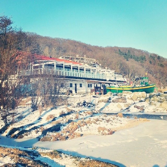 clear sky, mountain, transportation, built structure, architecture, water, building exterior, mode of transport, house, tree, nature, nautical vessel, copy space, snow, day, river, outdoors, no people, boat, blue