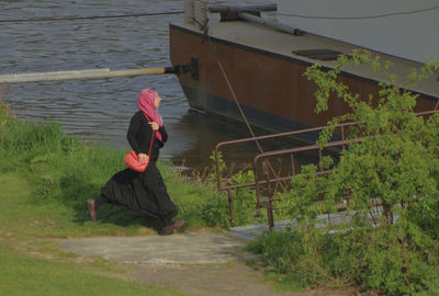 Rear view of woman sitting in water
