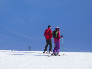 Rear view of people skiing on snowcapped mountain