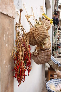 Dry red chili peppers and wicker baskets hanging on wall