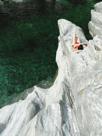 High angle view of woman on rock over lake