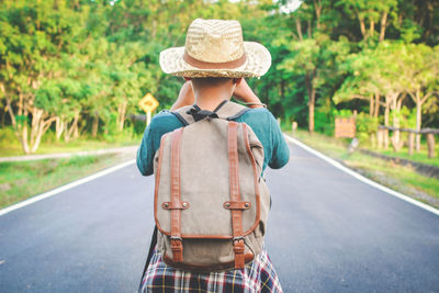 Rear view of boy walking on road