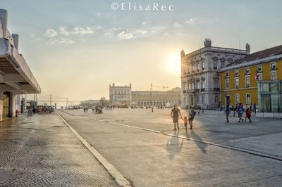 People walking on street against buildings in city