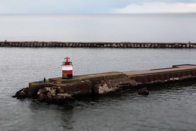 Lighthouse on sea against sky