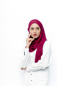 Portrait of a young woman against white background