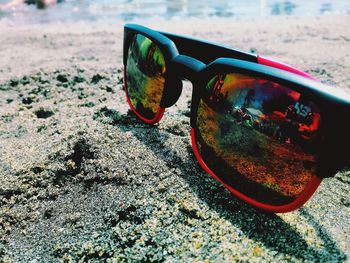 Close-up of sunglasses on beach against sky