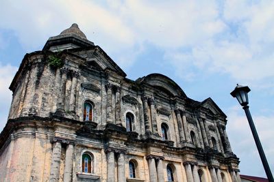 Low angle view of old building against cloudy sky