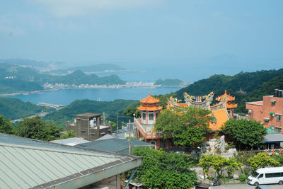 High angle view of townscape by sea against sky