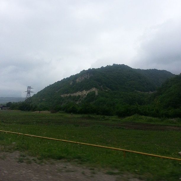 mountain, landscape, sky, tranquil scene, tranquility, scenics, tree, nature, cloud - sky, beauty in nature, mountain range, electricity pylon, field, non-urban scene, power line, cloudy, hill, rural scene, green color, fuel and power generation