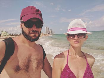 Portrait of young couple standing at beach