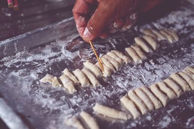 Cropped hand of man preparing food on table