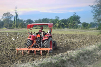 Farmer plaughing farm land with tractor 