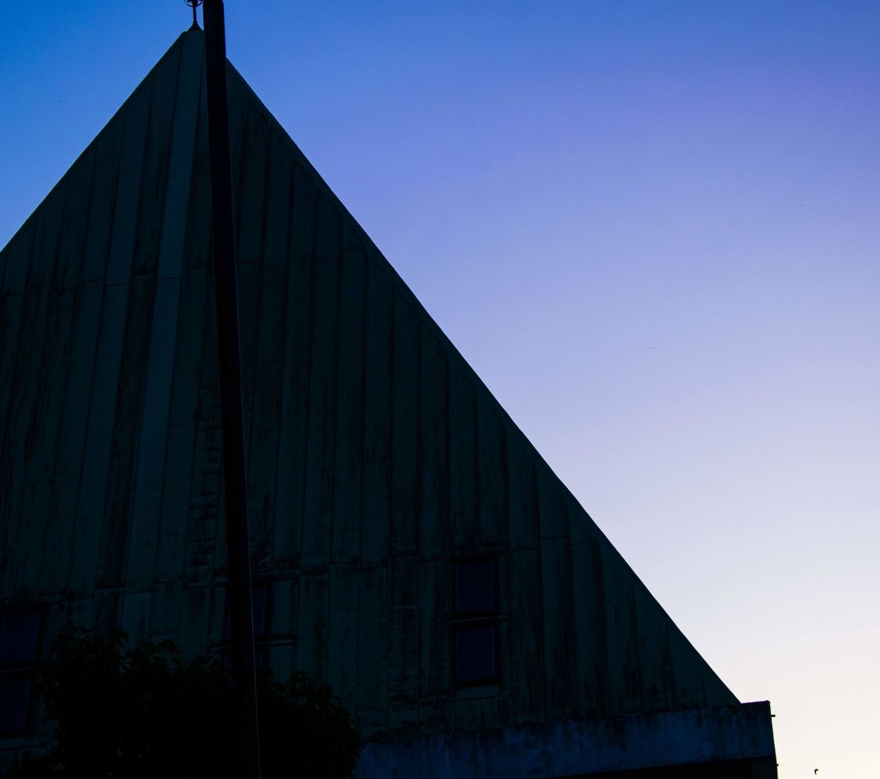 LOW ANGLE VIEW OF SILHOUETTE BUILDING AGAINST BLUE SKY