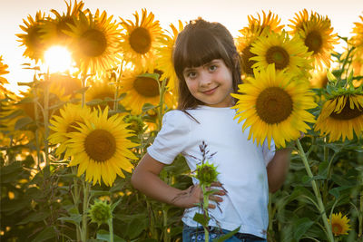 Portrait of cute girl standing on sunflower