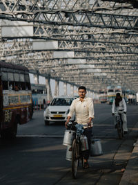 Full length of man riding bicycle on city