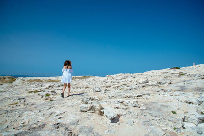 Rear view of woman standing on beach