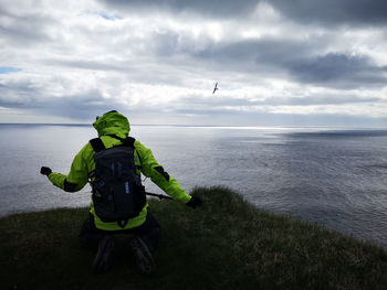 Rear view of man in sea against sky