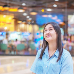 Portrait of young woman standing in cafe