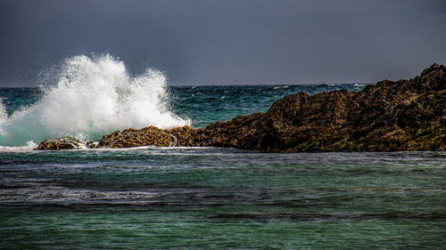 Wave breaking over rocks at lulworth cove, uk