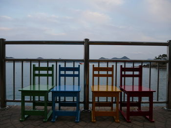 Chairs on beach against sky