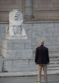 Rear view of man standing against wall