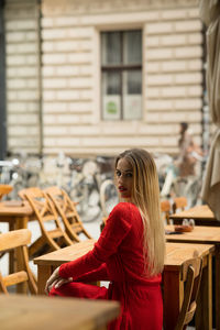 Portrait of smiling young woman sitting in city