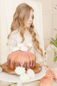 Cute girl by cake at home