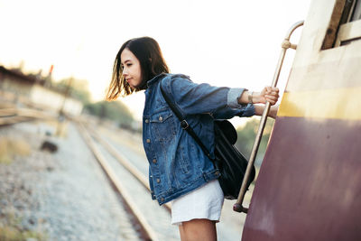 Young woman hanging from train