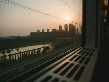 Buildings in city against sky during sunset