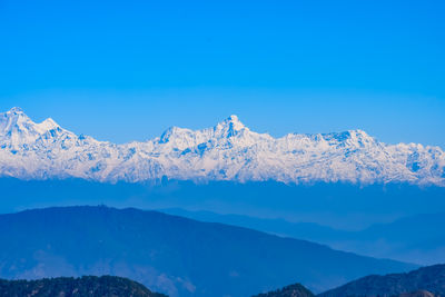 Scenic view of snowcapped mountains against clear blue sky