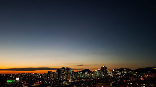 Illuminated cityscape against sky at night