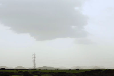 Electricity pylon on mountain against sky