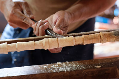 Midsection of man working on wood