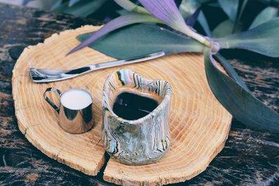 Black coffee and milk in mug on cutting board