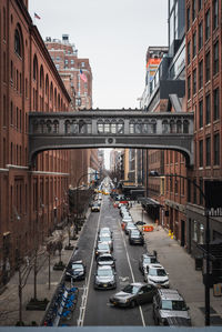 Traffic on road amidst buildings in new york city against sky