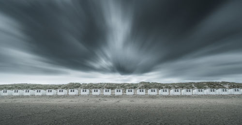 Scenic view of houses at beach against sky