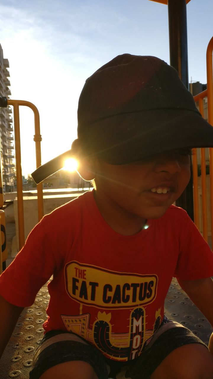 PORTRAIT OF SMILING BOY SITTING ON TOP OF WOMAN