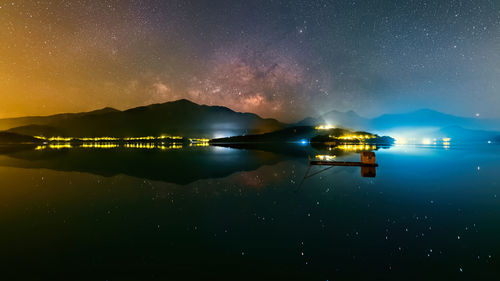 Scenic view of lake against sky at night