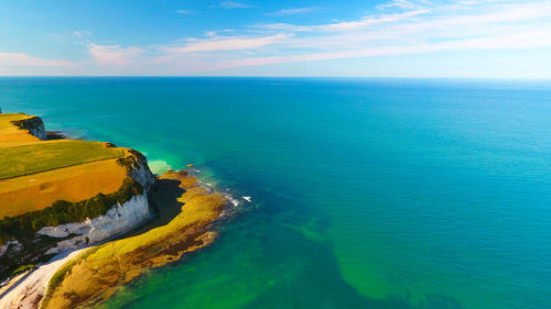 Idyllic shot of cliff in sea against sky