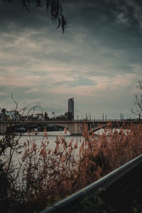 Bridge over river against sky at sunset