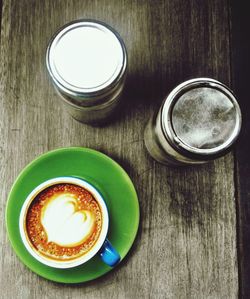 Directly above shot of cappuccino with containers on table