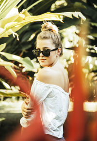 Portrait of young woman wearing sunglasses standing outdoors