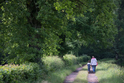 Mother and her daughter walking alone on a country lane