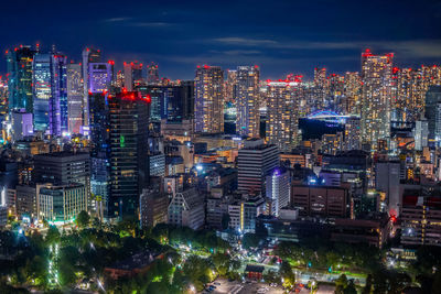 Illuminated cityscape against sky at night